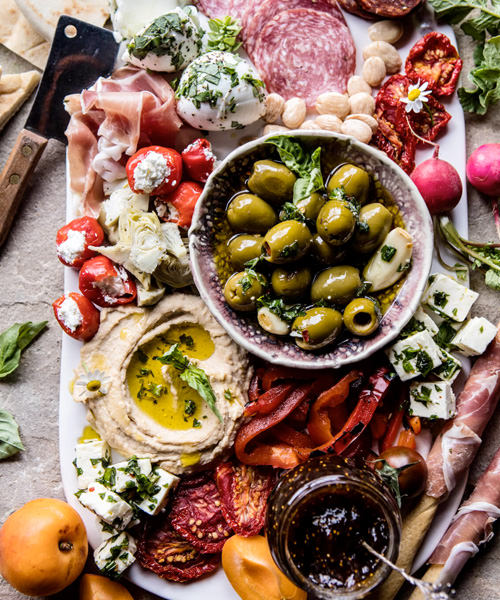 We're Obsessed With These 15 Swoon-Worthy Cheese & Charcuterie Boards Mediterranean Stuffed Tomatoes Olives Hummus Feta Mozzarella