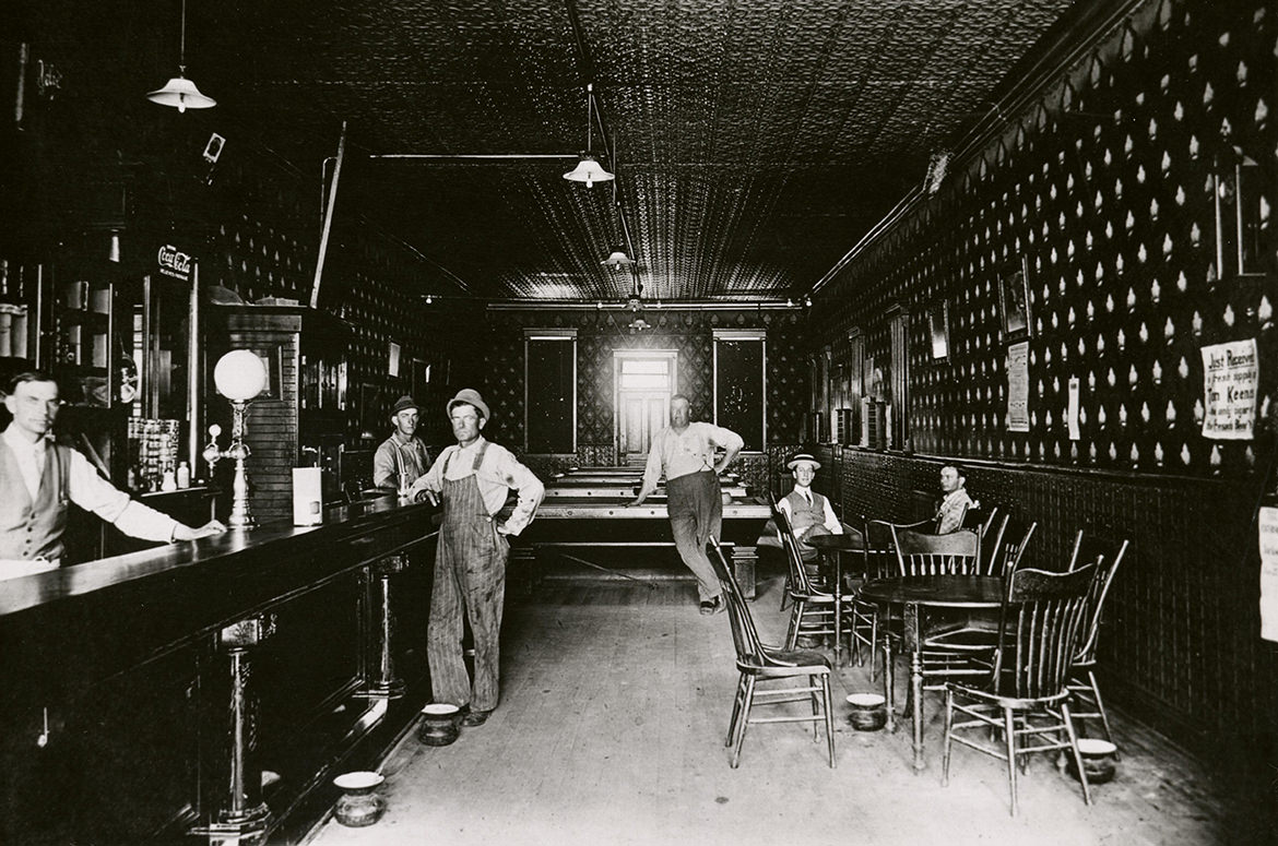 In the Old West at the turn of the 20th century, saloon life at the Behling Brothers Pool Room.