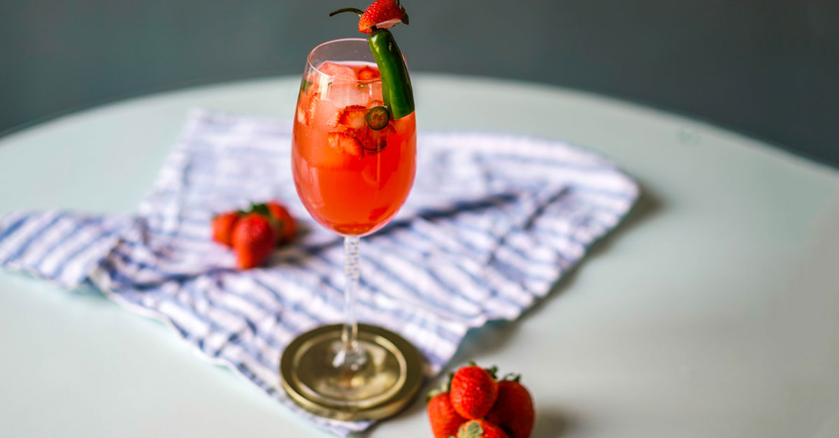 Want to spice up your spritz game? This unusual and easy tequila cocktail combines strawberries and Serrano chili. Learn how to make the recipe.